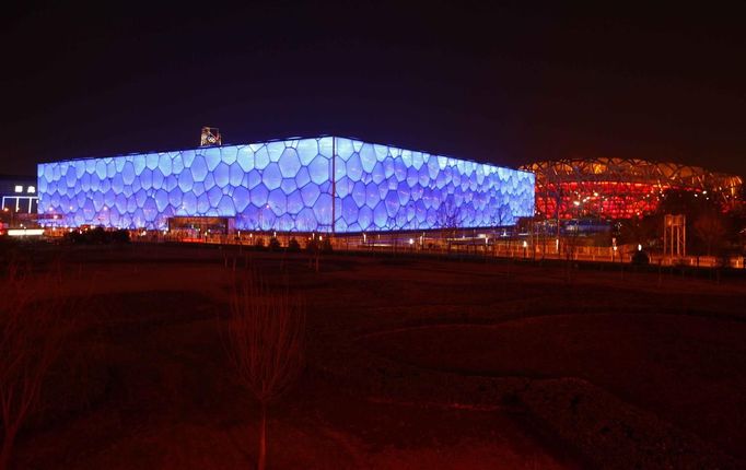 Národní plavecké centrum a Národní stadion, známý jako Ptačí hnízdo, který vznikl pro Olympijské hry v Pekingu, před zhasnutím.