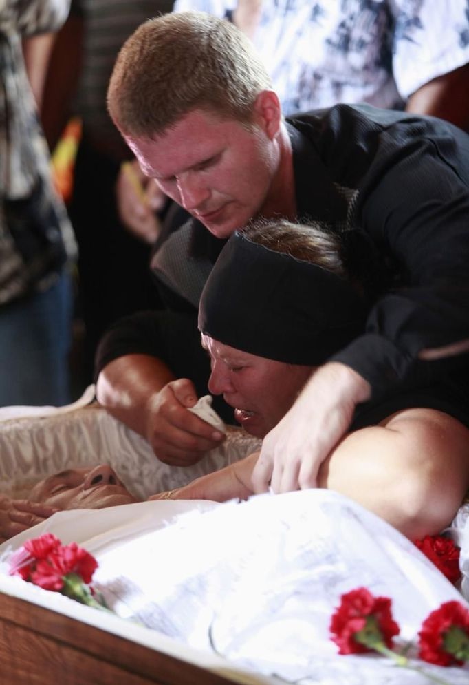 Relatives and acquaintances mourn near a coffin with Pyotr Ostapenko, 35, a flood victim, during a religious ceremony before the funeral in the village of Moldavanskoye outside Krymsk in Krasnodar region, southern Russia, July 8, 2012. The Russian President ordered investigators to find out if enough was done to prevent 144 people being killed in floods in southern Russia after flying to the region to deal with the first big disaster of his new presidency. REUTERS/Eduard Korniyenko (RUSSIA - Tags: DISASTER ENVIRONMENT OBITUARY RELIGION POLITICS) Published: Čec. 8, 2012, 3:50 odp.