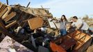 Greg Satterlee (R) shows his wife Genni where he thinks a file cabinet containing important papers may be in their tornado-destroyed home in Moore, Oklahoma May 21, 2013. Rescuers went building to building in search of victims and thousands of survivors were homeless on Tuesday after a massive tornado tore through the Oklahoma City suburb of Moore, wiping out whole blocks of homes and killing at least 24 people. REUTERS/Rick Wilking (UNITED STATES - Tags: DISASTER ENVIRONMENT) Published: Kvě. 22, 2013, 1:44 dop.