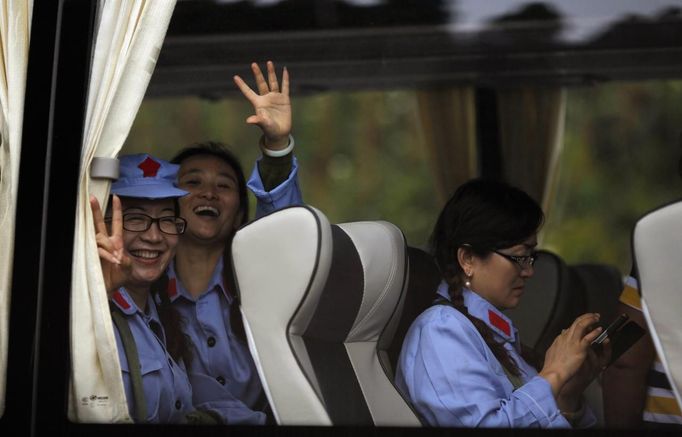 Mid-level government officials dressed in red army uniforms wave as they leave on a bus during their 5-day training course at the communist party school called China Executive Leadership Academy of Jinggangshan, in Jiangxi province September 21, 2012. China Executive Leadership Academy was established in 2005 by the Central Committee of the Communist Party of China, after the 16th Communist Party Congress in 2002. By the end of August 2012, the academy has held 789 training classes for almost 40,000 people. During the course, trainees listen and sing revolutionary songs, visit old revolutionary sites and review historical communist materials. China has yet to announce the starting date for the 18th Communist Party Congress, China's biggest political meeting in a decade, which will see the transfer of power from President Hu Jintao and Premier Wen Jiabao to a new generation. REUTERS/Carlos Barria (CHINA - Tags: POLITICS SOCIETY TRANSPORT) Published: Zář. 21, 2012, 2:23 odp.