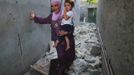 A woman carries her child while walking through the rubble in Attarib, on the outskirts of Aleppo province July 30, 2012. REUTERS/Zohra Bensemra (SYRIA - Tags: POLITICS CONFLICT CIVIL UNREST) Published: Čec. 30, 2012, 7:21 odp.