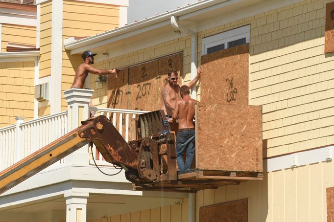 Crew work to board up homes in Oak Island, N.C., Tuesday Sept. 11, 2018, in preparation for Hurricane Florence.