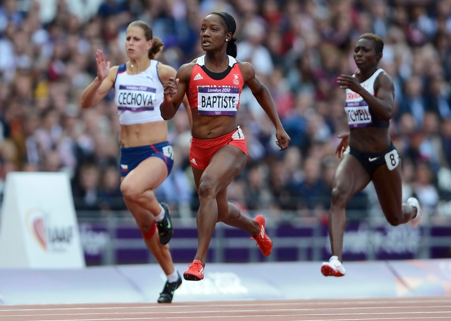 Česká sprinterka Kateřina Čechová (vlevo) dobíhá za Kelly-Ann Baptisteovou z Trinidadu a Tobaga (uprostřed) a před Kerri-Ann Mitchellovou z Kanady v závodě na 100 metrů na OH 2012 v Londýně.