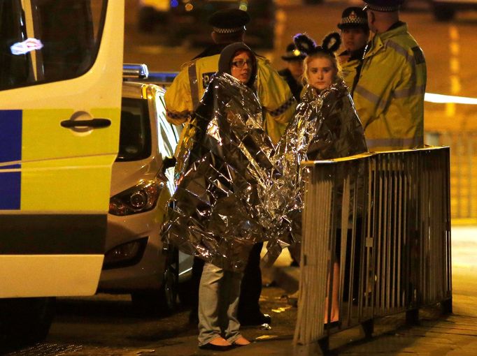 Dívky s termodekami a policiste před halou v Manchesteru.