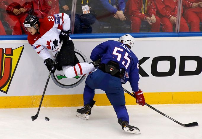 Nathan MacKinnon of Canada (L) is knocked to the ice by Jonathan Janil of France (R) during the first period of their men's ice hockey World Championship Group A game at