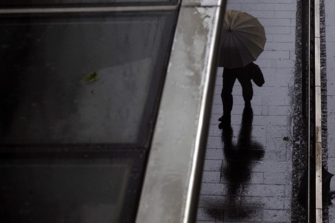 A man walks in the rain along a street in Hong Kong's business central district as Typhoon Vicente approaches July 24, 2012. Hong Kong raised its highest tropical cyclone warning on Tuesday as an intensifying severe typhoon edged closer towards the financial hub, grounding flights and forcing the port to close.Financial markets, schools, businesses and non-essential government services close when any No. 8 or above signal is hoisted, posing a disruption to business in the capitalist hub and former British colony that returned to Chinese rule in 1997.REUTERS/Tyrone Siu (CHINA - Tags: ENVIRONMENT DISASTER) Published: Čec. 24, 2012, 1:06 dop.