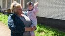 Ludmila, která pracuje v místním zdravotním zařízení, v náručí drží vnučku Polinu.