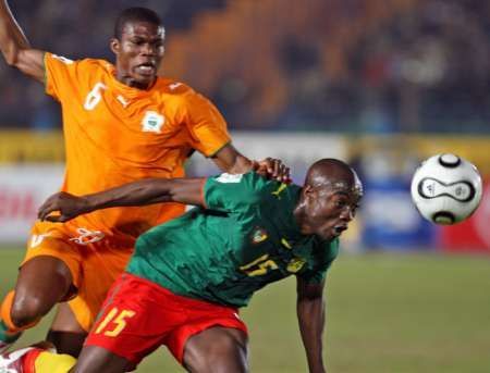 Fotbalista Pobřeží Slonoviny Blaise Kossi v souboji s Achille Webem na mistrovství Afriky v Káhiře