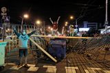 Protestující staví na ulicích barikády.
