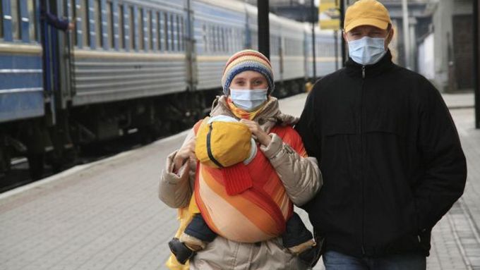 Rodina s rouškami na nádraží v ukrajinském Ternopolu.