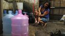 A native Indian woman bathes a baby at the Brazilian Indian Museum in Rio de Janeiro March 21, 2013. A native Indian community of around 30 individuals have been living in the abandoned Indian Museum since 2006. They have expired a deadline given by a court last Friday to leave the museum within 3 days, local media reported. The group is fighting against the destruction of the museum, which is next to the Maracana Stadium. REUTERS/Pilar Olivares (BRAZIL - Tags: POLITICS SPORT SOCCER) Published: Bře. 21, 2013, 11:52 dop.