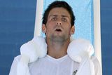 Novak Djokovič se snaží ve čtvrtfinále proti Roddickovi ochladit ledem - nepomohlo to, obhájce titulu musel zápas vzdát.