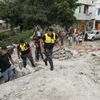 Police officers search through debris after an earthquake struck off Ecuador's Pacific coast, at Tarqui neighborhood in Manta