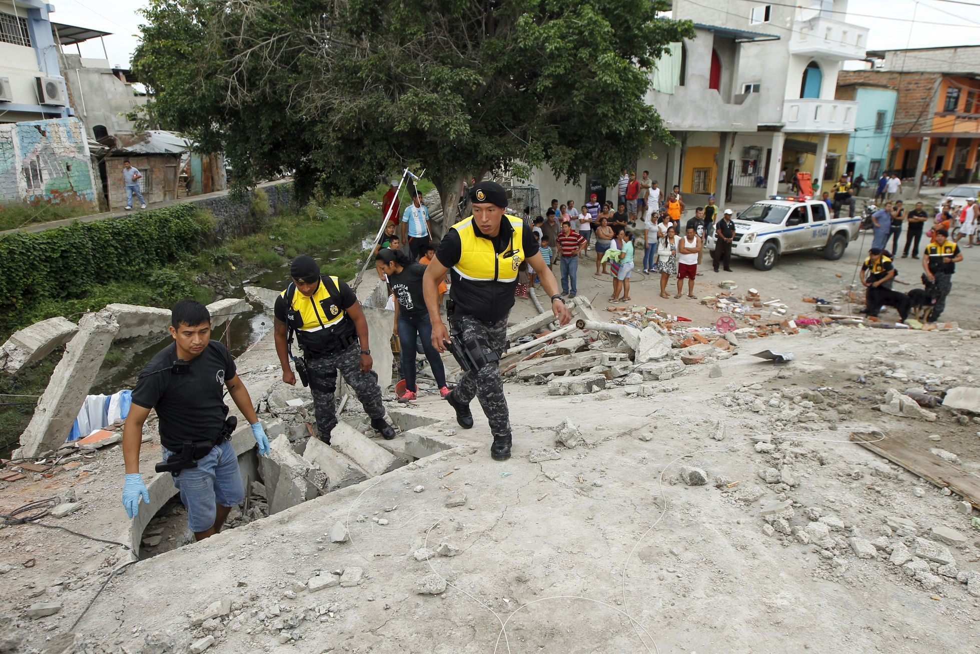 Police officers search through debris after an earthquake struck off Ecuador's Pacific coast, at Tarqui neighborhood in Manta