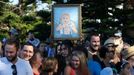 A supporter of Britain's Prince William and his wife Catherine, the Duchess of Cambridge, holds up a framed painting of their son Prince George at Sydney's Manly beach