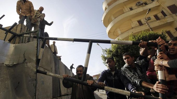 Odpůrci prezidenta Mursího se pokoušejí prolomit ochranou bariéru před prezidentským palácem.