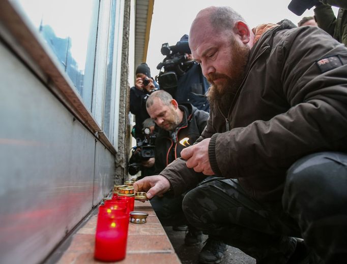 U místa důlního neštěstí zapalují lidé svíčky.