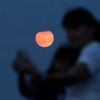 A supermoon rises as a mother and her daughter take selfies in Monterrey
