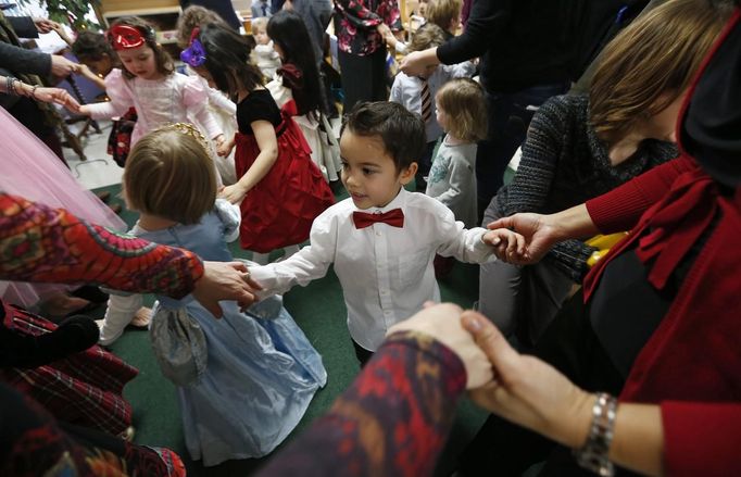 Jaidon Santos-Volpe (C) dances with his two mothers Theresa Volpe (L) and Mercedes Santos during the Valentine's Day Ball at Baker Demonstration School in Wilmette, Illinois, February 13, 2013. Santos and Volpe are a same-sex couple raising two of their biological children as they struggle to get same-sex marriages passed into law in Illinois. Picture taken February 13, 2013. REUTERS/Jim Young (UNITED STATES - Tags: SOCIETY) Published: Bře. 25, 2013, 6:06 odp.