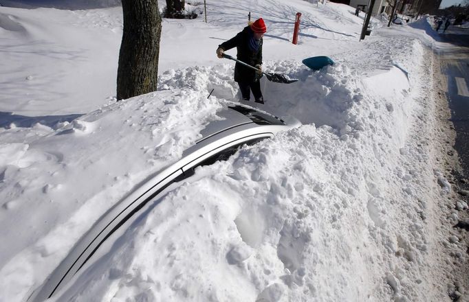 Julie MacDonald starts to dig her car out from snow in Somerville, Massachusetts February 10, 2013 following a winter blizzard which dumped up to 40 inches of snow with hurricane force winds, killing at least nine people and leaving hundreds of thousands without power. REUTERS/Brian Snyder (UNITED STATES - Tags: ENVIRONMENT) Published: Úno. 10, 2013, 6:55 odp.