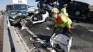 A rescue worker works amongst the wreckage of some of the 100 vehicles involved in multiple collisions, which took place in dense fog during the morning rush hour, on the Sheppey Bridge in Kent, east of London, September 5, 2013. Eight people were seriously injured and dozens hurt in the multiple crashes.