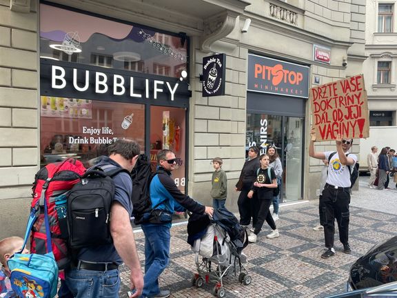 Jeden z odpůrců Pochodu pro život stojí s transparentem před účastníky pochodu, kteří se rozcházeli domů.