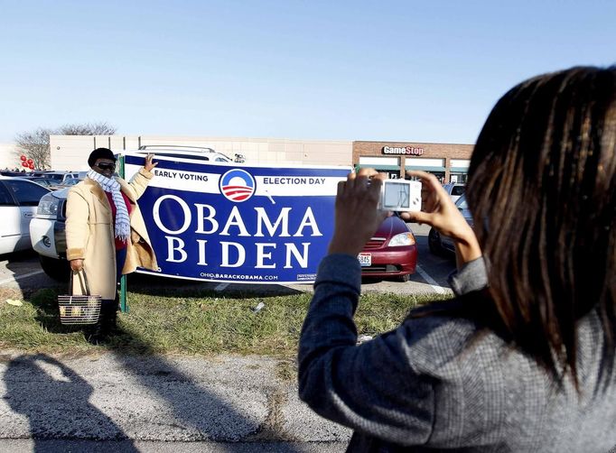 Voters take a picture with signs after casting their ballots at the Franklin County in-person absentee voting location in Columbus, Ohio November 5, 2012. REUTERS/Matt Sullivan (UNITED STATES - Tags: ELECTIONS POLITICS USA PRESIDENTIAL ELECTION) Published: Lis. 5, 2012, 4:09 odp.