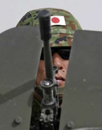 Japonský voják dohlíží na průběh oslav ášúrá.