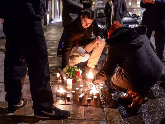 Lidé zapalují svíčky ve švédském Stockholmu.