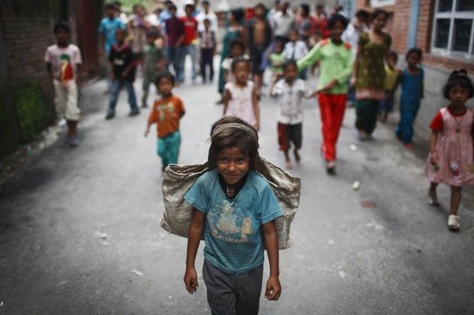 Children follow Shivani Choudhary, 7, a street performer while she returns after finishing her street performance in Kathmandu August 15, 2012. Shivani and her brothers Drumpal and Gchan, who came to Kathmandu from India 5 years ago, earn their living by performing tricks on the streets of Kathmandu. According to Drumpal, Shivani's older brother, they earn around $10 a day by performing tricks, which is not enough to feed their 10-member family living together in a small hut without a proper toilet or any basic needs. REUTERS/Navesh Chitrakar (NEPAL - Tags: SOCIETY POVERTY IMMIGRATION) Published: Srp. 15, 2012, 4:33 odp.