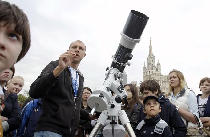 Russian astronomy fans listen to the explanations of a Moscow Planetarium staff member during an early morning session to view the transit of the planet Venus over Moscow, June 6, 2012. Cloudy weather prevented Muscovites from seeing the transit, which occurred on Tuesday, the last such passing that will be visible from Earth for 105 years. REUTERS/Denis Sinyakov (RUSSIA - Tags: ENVIRONMENT SCIENCE TECHNOLOGY) Published: Čer. 6, 2012, 6:21 dop.