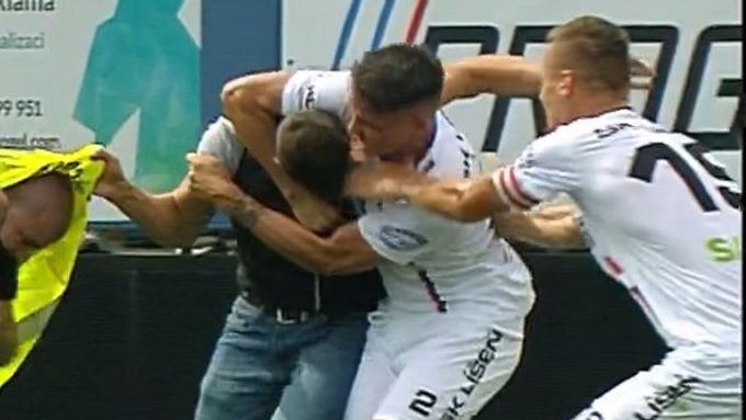 Fotbalista Líšně Jan Silný pacifikuje výtržníka, který vběhl na trávník a napadl pořadatele při druholigovém utkání se Zbrojovkou Brno