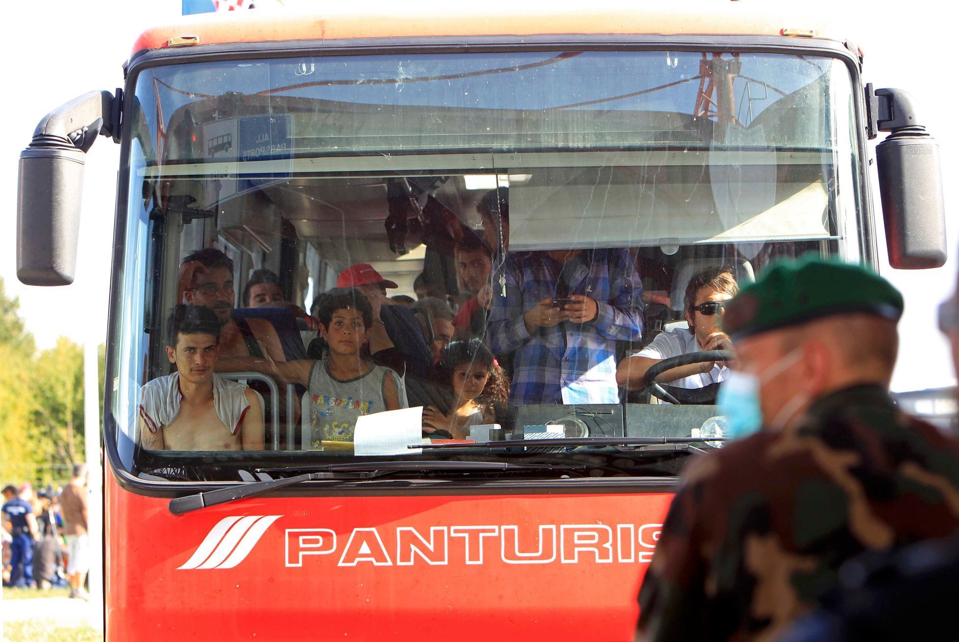 Běženci sedí v autobusu na maďarské straně hranice.