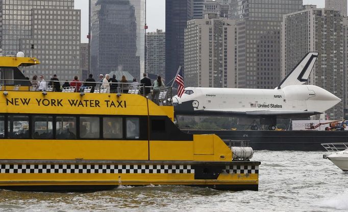 The Space Shuttle Enterprise, passes a water taxi in New York harbor, June 6, 2012. The Space Shuttle Enterprise was being moved up the Hudson River to be placed at the Intrepid Sea, Air and Space Museum. REUTERS/Mike Segar (UNITED STATES - Tags: TRANSPORT SCIENCE TECHNOLOGY) Published: Čer. 6, 2012, 6:12 odp.