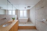 Koupelna, která si prohodila místo s kuchyní, je velkorysá. Má vanu oddělenou prosklenou stěnou, umyvadlo a finskou saunu.