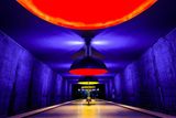 Stanice Westfriedhof, Mnichov, Německo. Velká kupolovitá světla zalévají nástupiště modrým, červeným a žlutým světlem, stěny připomínají skálu jeskyně. Začátek provozu - květen 1998.