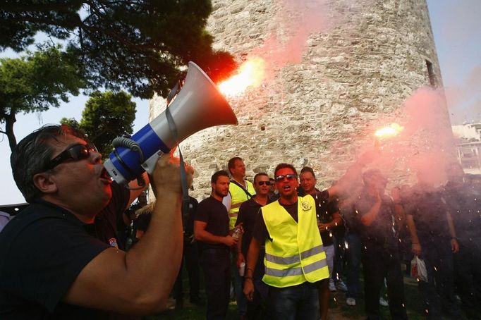 Coast guard personnel wave flares in front of the city's landmark White Tower, during a rally in Thessaloniki in northern Greece September 8, 2012. Greece hopes a major state sell-off this autumn will persuade international inspectors arriving on Friday to keep the country's aid lifeline open despite scant progress on reforms promised in return for the cash. REUTERS/Grigoris Siamidis (GREECE - Tags: CIVIL UNREST POLITICS BUSINESS) Published: Zář. 8, 2012, 12:30 odp.