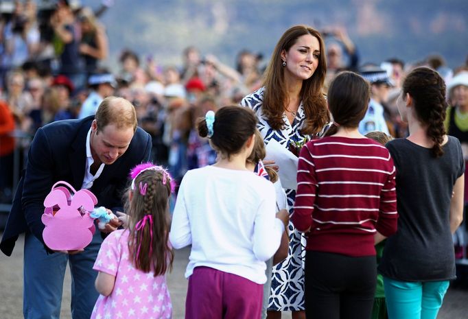 Britain's Prince William and his wife Catherine, the Duchess of Cambridge, receive gifts from a group of children during a tour of Echo Point in the Blue Mountains town o