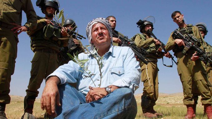 Izraelští vojáci a palestinský farmář v údolí Jordánu.