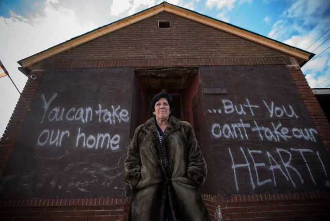 Linda Restaino poses for a photograph in front of a message written by her son on the boarded up back wall of her property which was flooded during Hurricane Sandy in New Dorp Beach, Staten Island November 14, 2012. Restaino, who has lived at the property for 35 years, is now hoping to leave Staten Island. Picture taken November 14, 2012 REUTERS/Mike Segar (UNITED STATES - Tags: DISASTER ENVIRONMENT) ATTENTION EDITORS PICTURE 19 OF 19 FOR PACKAGE 'SURVIVING SANDY' SEARCH 'SEGAR SANDY' FOR ALL PICTURES Published: Lis. 20, 2012, 3:31 odp.