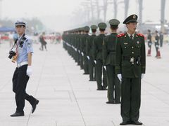 Čínská polovojenská policie před Ptačím hnízdem v Pekingu.