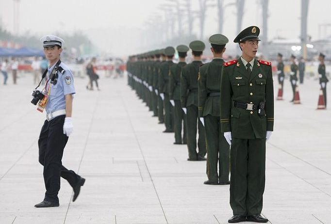 Čínská polovojenská policie před Ptačím hnízdem v Pekingu.