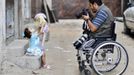 Wheelchair-bound Palestinian freelance photographer Moamen Qreiqea takes pictures of his daughter outside his home in Gaza City October 1, 2012. Qreiqea, 25, lost both his legs in an Israeli air strike in 2008 while taking pictures east of Gaza. The father of two is determined to continue his career despite his disability. REUTERS/Suhaib Salem (GAZA - Tags: MEDIA SOCIETY) Published: Říj. 1, 2012, 3:39 odp.