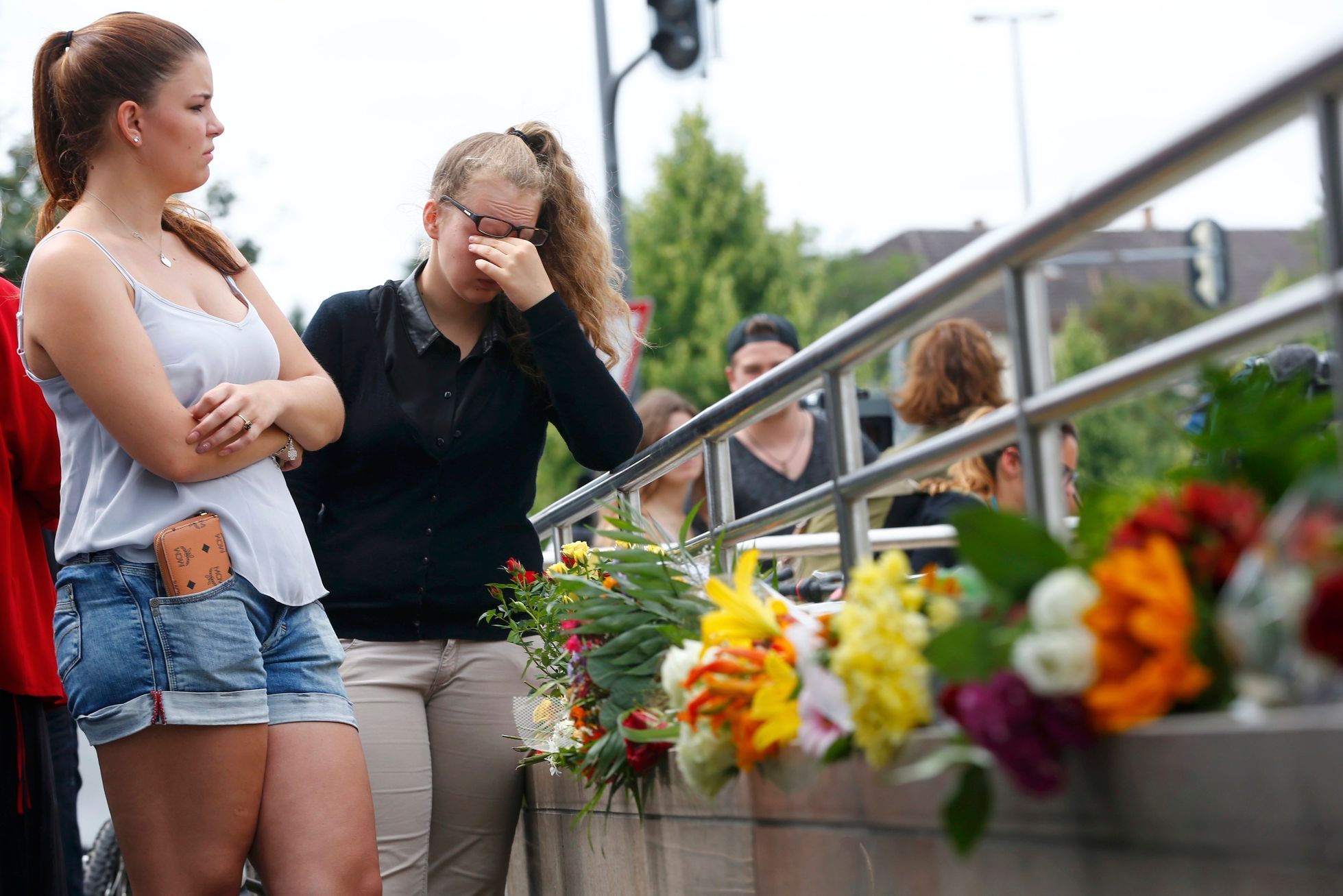 Lidé přinášejí květiny k místu pátečního útoku šíleného střelce v Mnichově.