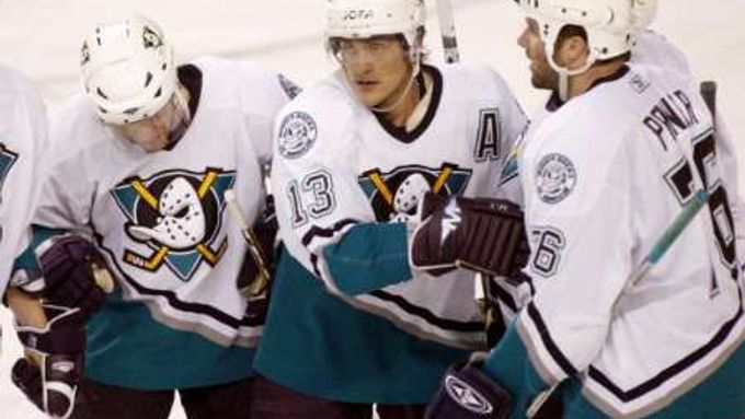 Útočník Anaheimu Teemu Selanne příjimá gratulace od spoluhráčůs Andyho MacDonalda (vlevo) a Dustina Pennera poté, co Selanne otevřel skóre zápasu na ledě Calgary.