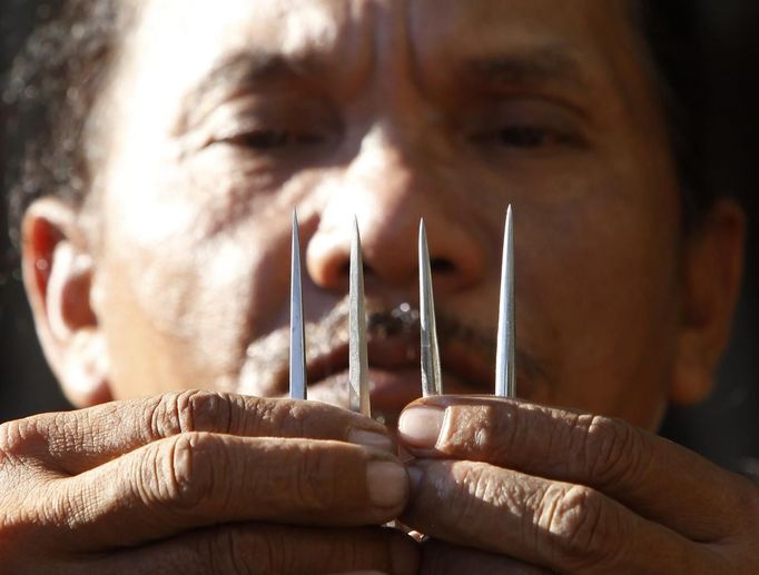 Ruben Enaje, 52, who will portray as Jesus Christ for the 27th time, shows three-inch nail which he will use on a Good Friday crucifixion re-enactment in San Pedro Cutud town, Pampanga province, north of Manila March 29, 2013. The Roman Catholic church frowns on the gory spectacle held in the Philippine village of Cutud every Good Friday but that does nothing to deter the faithful from emulating the suffering of Christ and taking a painful route to penitence. Holy Week is celebrated in many Christian traditions during the week before Easter. REUTERS/Romeo Ranoco (PHILIPPINES - Tags: POLITICS RELIGION SOCIETY TPX IMAGES OF THE DAY) Published: Bře. 29, 2013, 4:12 dop.