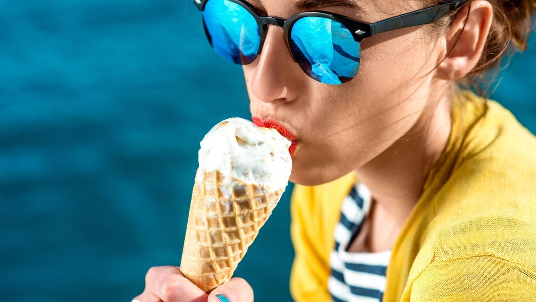 Вкусно ест мороженое. Мороженое. Человек ест мороженое. С мороженым. Девушки кушают мороженая в море.