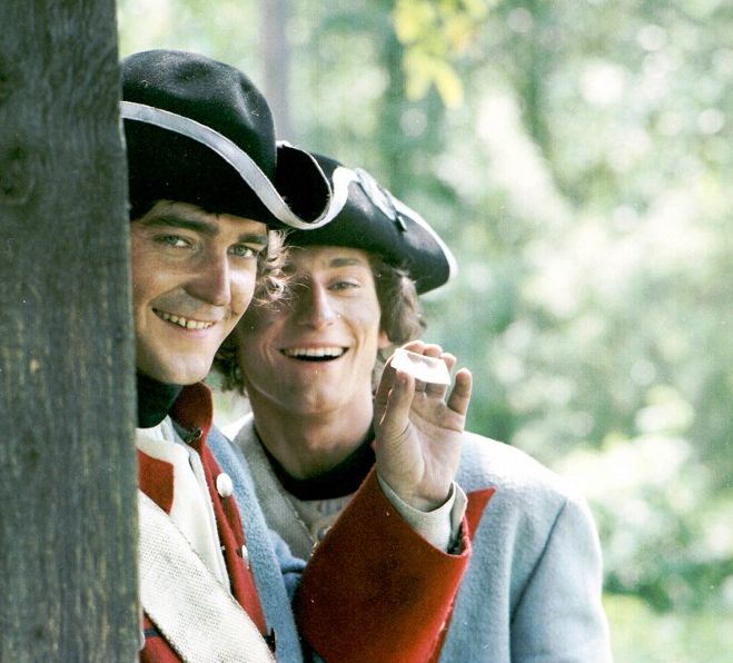 Vladimír Dlouhý jako Petr Máchal a Ondřej Vetchý coby čert Janek se ve filmu S čerty nejsou žerty pokoušejí na dálku zapálit ozdobné peří ve vlasech zlé macechy Doroty. | Foto: Filmové studio Barrandov