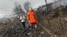 Keith Klein and Eileen Blair (L) walk among homes devastated by fire and the effects of Hurricane Sandy at the Breezy Point section of the Queens borough in New York October 30, 2012. Millions of people across the eastern United States awoke on Tuesday to scenes of destruction wrought by monster storm Sandy, which knocked out power to huge swathes of the nation's most densely populated region, swamped New York's subway system and submerged streets in Manhattan's financial district. REUTERS/Shannon Stapleton (UNITED STATES - Tags: DISASTER ENVIRONMENT) Published: Říj. 30, 2012, 1:45 odp.