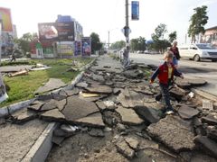 Krymští obyvatelé procházejí ulicí zničenou povodní